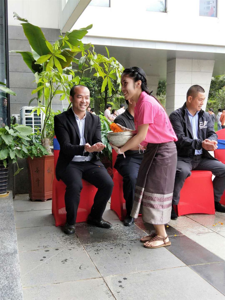 老撾駐廣西留學(xué)生代表將浸有花瓣的香水灑客人的手上，表示對(duì)嘉賓的美好祝福（圖一）